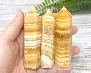 Banded Orange Calcite Towers in hand