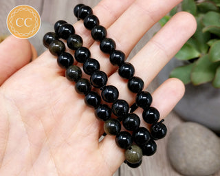 Gold Sheen Obsidian 8mm Beaded Bracelet in hand