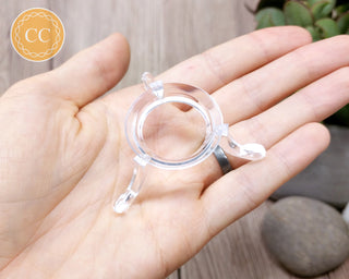Clear plastic sphere stand in hand