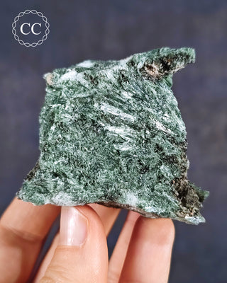 A hand holding an Actinolite mineral specimen from Otjiwarongo, Namibia