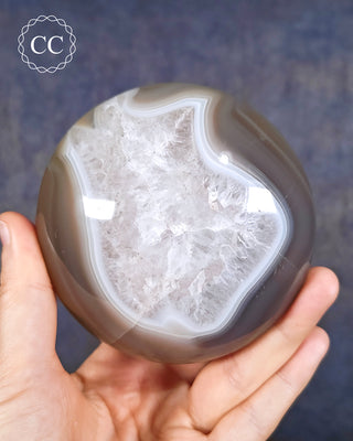 A hand holding unique "cushion" shaped Agate freeform with Quartz centre from Madagascar