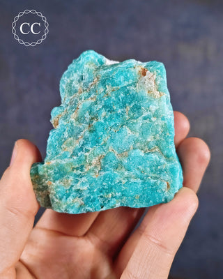 Amazonite from Minas Gerais in Brazil, held in a hand.