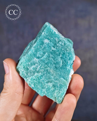 Amazonite from Minas Gerais in Brazil, held in a hand.