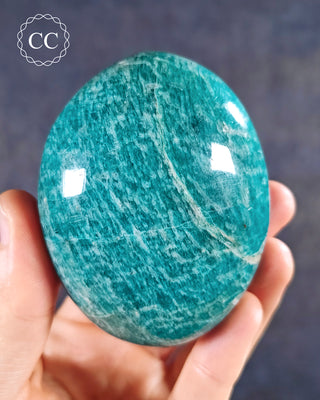 A hand holding an Amazonite Chunky Palmstone from Madagascar