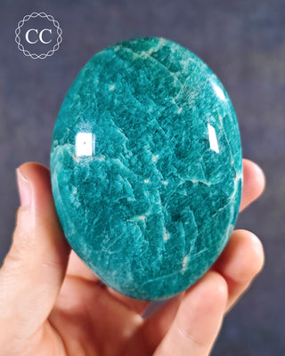 A hand holding an Amazonite Chunky Palmstone from Madagascar