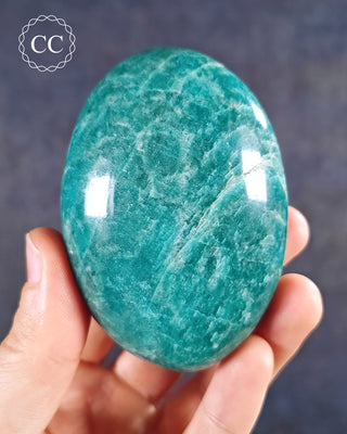 A hand holding an Amazonite Chunky Palmstone from Madagascar