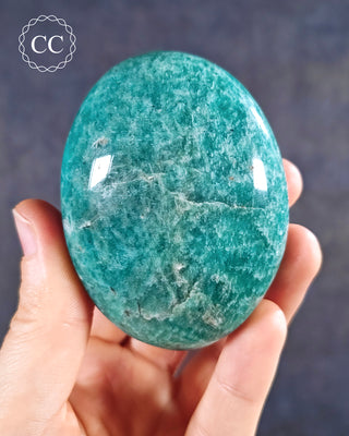 A hand holding an Amazonite Chunky Palmstone from Madagascar