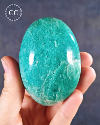 A hand holding an Amazonite Chunky Palmstone from Madagascar