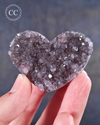 A hand holding an Amethyst Cluster Heart from Brazil
