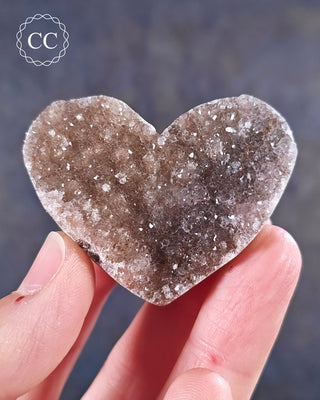 A hand holding an Amethyst Cluster Heart from Brazil