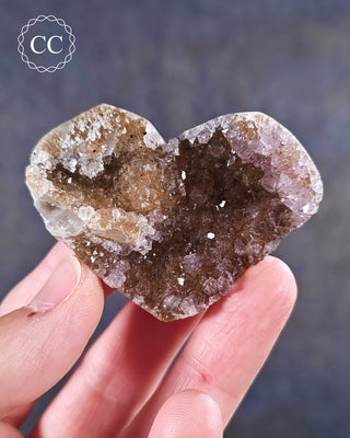 A hand holding an Amethyst Cluster Heart from Brazil
