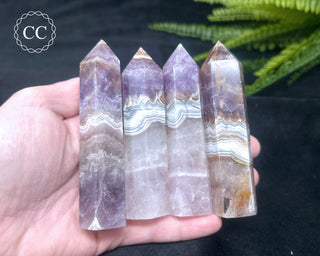 A hand holding four Amethyst and Agate Towers