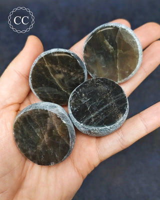 A hand holding 4 Black Moonstone Dragon Eggs 