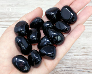 Black Obsidian tumbled crystals in hand