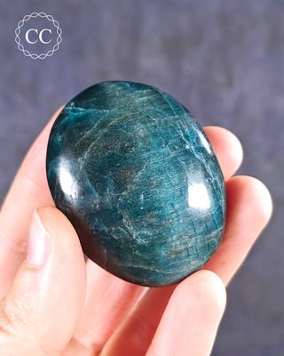 A hand holding a Blue Apatite Chunky palmstone from Madagascar