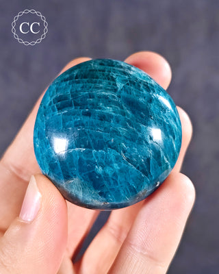 A hand holding a Blue Apatite Chunky palmstone from Madagascar