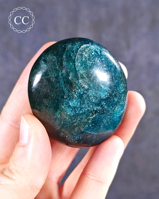 A hand holding a Blue Apatite Chunky palmstone from Madagascar