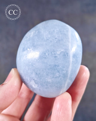 A hand holding a Blue Calcite Chunky Palmstone from Madagascar