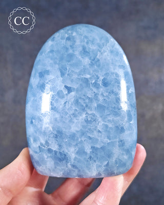 A hand holding a Blue Calcite freeform from Madagascar