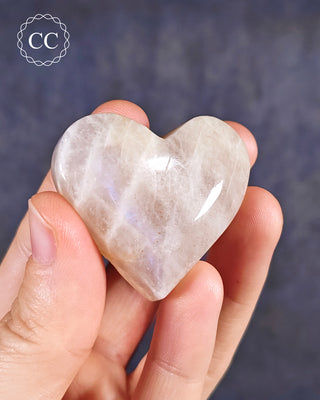 A hand holding a Blue Moonstone Heart
