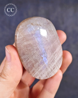A hand holding a Blue Moonstone Palmstone