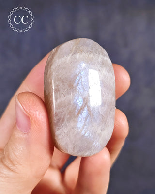 A hand holding a Blue Moonstone Palmstone