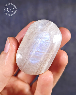 A hand holding a Blue Moonstone Palmstone