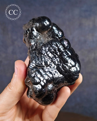 Large Botryoidal Hematite Specimen in hand on blue background