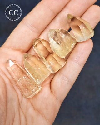 Brazilian Citrine Mini Tower in hand on dark blue background