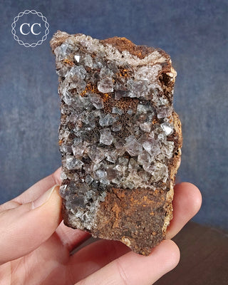A hand holding a specimen of Fluorite from Burtree Slits, Weardale, UK