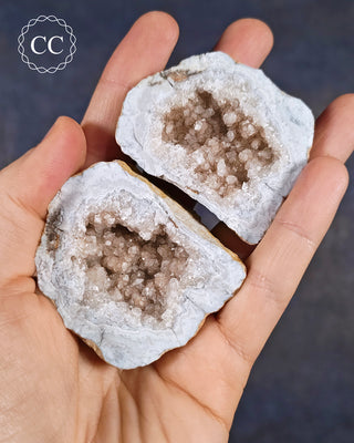 A hand holding a Calcite Geode pair is from Hamilton, Illinois,&nbsp;USA
