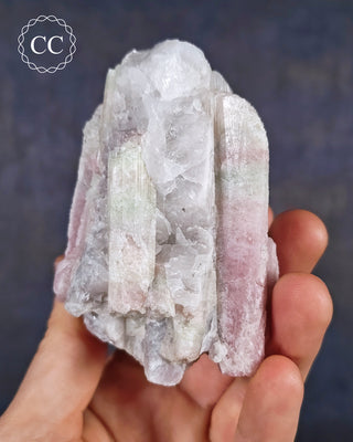 A hand holding soft candy coloured, ombre Tourmaline specimen from Brazil