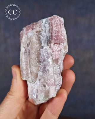 A hand holding soft candy coloured, ombre Tourmaline specimen from Brazil