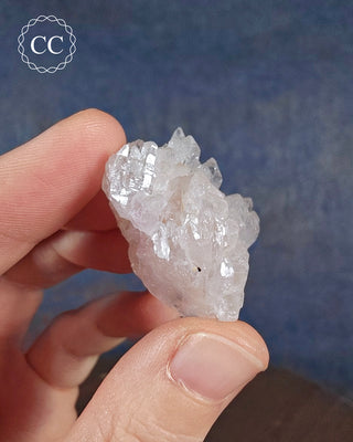 A hand holding arare Canga Rosa specimen, also known as Crystallised Rose Quartz specimen 
