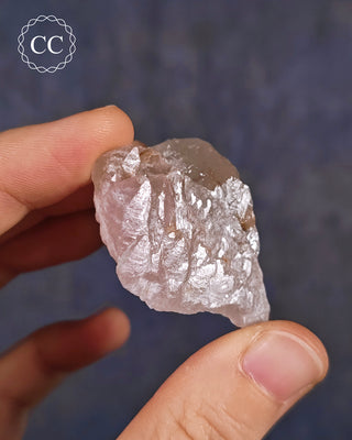 A hand holding a rare Canga Rosa specimen, also known as Crystallised Rose Quartz specimen 