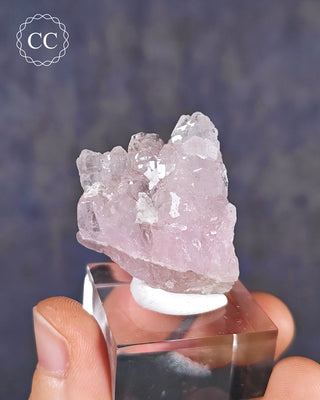 A clear display base showcasing a rare Canga Rosa specimen, also known as Crystallised Rose Quartz specimen