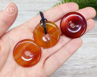 Carnelian Donut Necklaces in hand