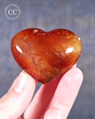 A hand holding a Carnelian Heart from Madagascar