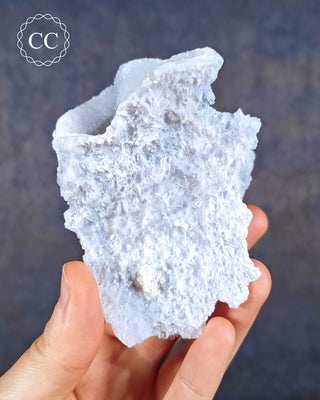 A hand holding a Celestial Blue Agate specimen from Malawi