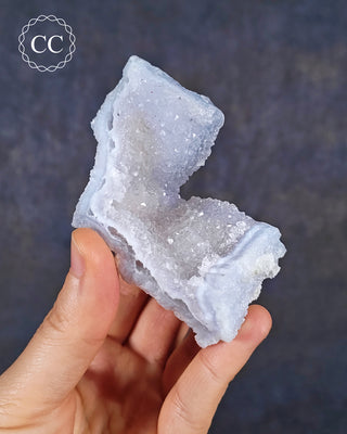 A hand holding a Celestial Blue Agate specimen from Malawi