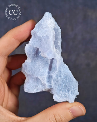 A hand holding a Celestial Blue Agate specimen from Malawi
