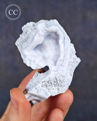 A hand holding a Celestial Blue Agate specimen from Malawi