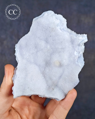 A hand holding a Celestial Blue Agate specimen from Malawi