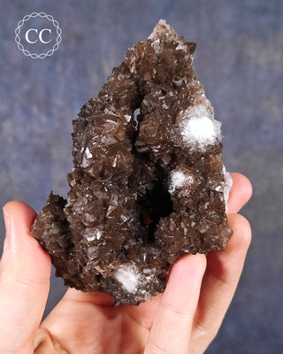 A hand holding a Chocolate Calcite specimen from Mexico 