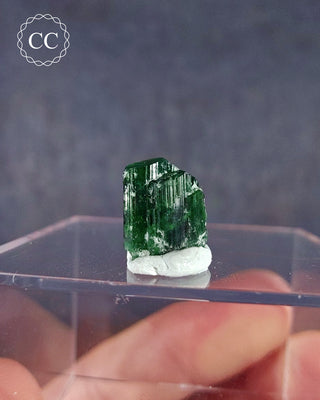  A rare Chrome Tourmaline mineral  from Tanzania on a clear display box 