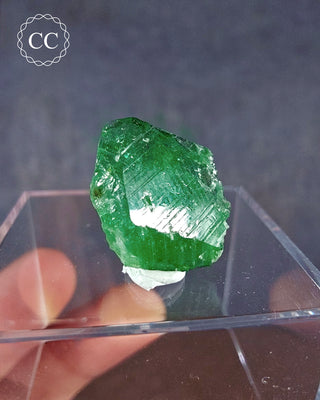  A rare Chrome Tourmaline mineral  from Tanzania on a clear display box 