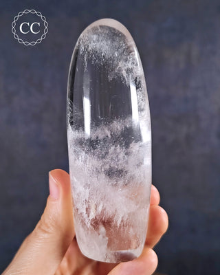 A hand holding a polished Clear Quartz Freeform from Madagascar