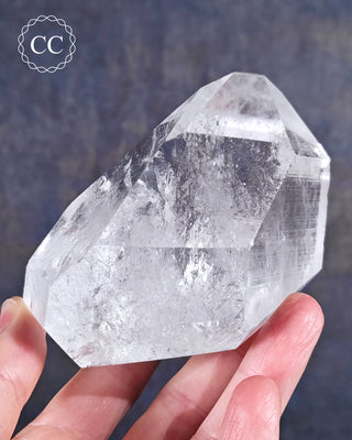 Fingers holding a Clear Quartz Tower from Brazil 