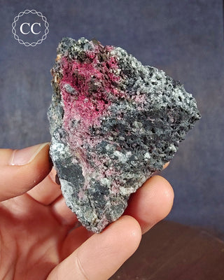 A hand holding a Cobaltan Calcite specimen from the famous Tynebottom Mine in Alson Moor, Cumbria, England