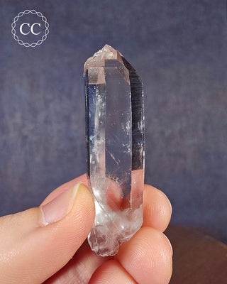 A hand holding a natural Colombian Quartz point 